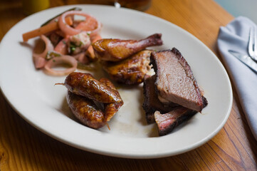 Barbecue catering platter with variety of meats. Traditional Texas BBQ: Beef brisket, beef ribs, pork ribs, sausage links, black pepper roasted chicken, and turkey served with homemade sauce.