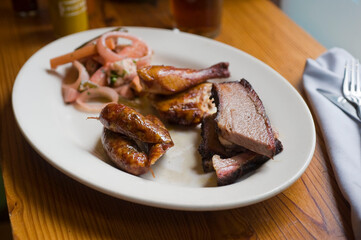 Barbecue catering platter with variety of meats. Traditional Texas BBQ: Beef brisket, beef ribs, pork ribs, sausage links, black pepper roasted chicken, and turkey served with homemade sauce.