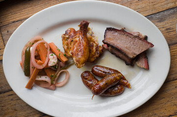 Barbecue catering platter with variety of meats. Traditional Texas BBQ: Beef brisket, beef ribs, pork ribs, sausage links, black pepper roasted chicken, and turkey served with homemade sauce.