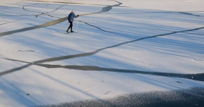 The man is engaged in winter skiing.
Sunny day, the skier is moving along the track.
