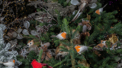 Christmas toys in the form of birds. Decorated christmas tree background. Happy new year concept.