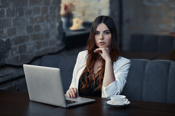 Business woman at work with laptop in cafe