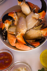 Stone crab claws. Colossal Crab claws served with lemons, spicy rémoulade sauce on top of a mixed green salad. Classic American restaurant or steakhouse appetizer or entree.