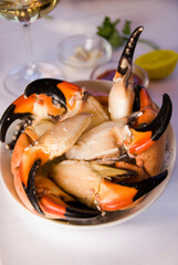 Stone crab claws. Colossal Crab claws served with lemons, spicy rémoulade sauce on top of a mixed green salad. Classic American restaurant or steakhouse appetizer or entree. © rebecca