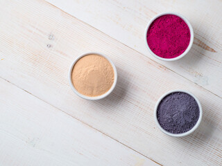 Set of superfoods in white bowls on wooden background.