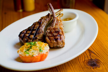 Lamb Chops. Grass-fed lamb, grilled to a medium rare and served with a garlic herb butter sauce and paired with roasted potatoes and Brussels sprouts. Classic American steakhouse favorite. 