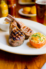 Lamb Chops. Grass-fed lamb, grilled to a medium rare and served with a garlic herb butter sauce and paired with roasted potatoes and Brussels sprouts. Classic American steakhouse favorite. 