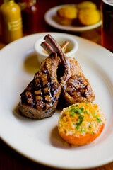 Lamb Chops. Grass-fed lamb, grilled to a medium rare and served with a garlic herb butter sauce and paired with roasted potatoes and Brussels sprouts. Classic American steakhouse favorite. 