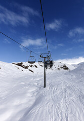 Chair-lift with skiers at winter mountains