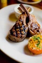 Lamb Chops. Grass-fed lamb, grilled to a medium rare and served with a garlic herb butter sauce and paired with roasted potatoes and Brussels sprouts. Classic American steakhouse favorite. 