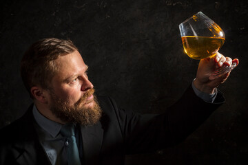 Solid confident bearded man in suit with glass of whisky