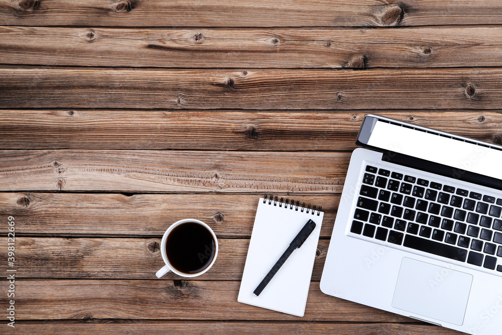 Poster laptop computer with cup of coffee and notepad on brown wooden table