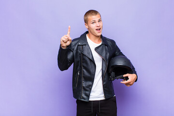 young blonde man feeling like a happy and excited genius after realizing an idea, cheerfully...