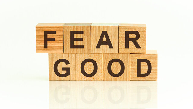 Fear Good - text on wooden cubes on a white gradient background