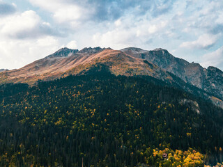 The greatness of the mountain at sunset in a beautiful autumn. Dombay. Russia. Drone shot