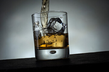Whisky Drink Pouring into a Glass with Ice