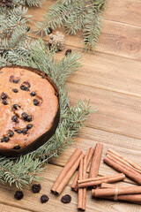 Pie with raisins among fir branches. Raisins and cinnamon sticks