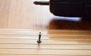 Fixing the threshold with an electric screwdriver. Repair of residential premises.