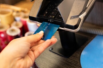 A customer paying with a credit card at the checkout counter machine. Shopping.