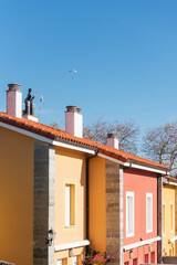 Unrecognizable person flies over a town on a powered paraglider. colorful houses. risk sports and adventure.