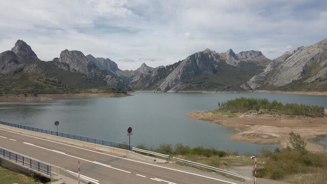PAN SHOT - Bridge over the Riano reservoir in Northern Spain. Yordas Peak towers over Riano, the Cantabrian Mountains, Castile-Leon region.