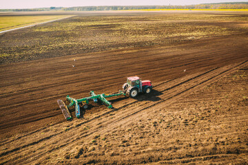 Aerial View. Tractor Plowing Field. Beginning Of Agricultural Spring Season. Cultivator Pulled By A...