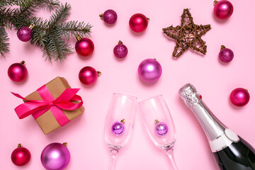 Christmas decorations and champagne on pink background