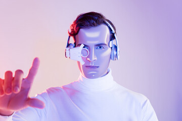 Cyborg in digital eye lens and headphones pointing with finger on blurred foreground on purple...