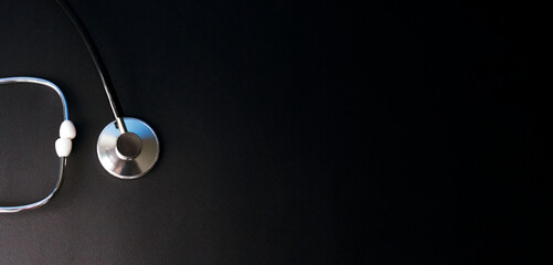 Black background along with a stethoscope with free space for your medical inscription.