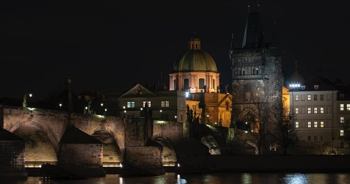 time lapse stone illuminated Charles Bridge and bridge tower on the Vltava river in the center of Prague at night and illuminated by street lights