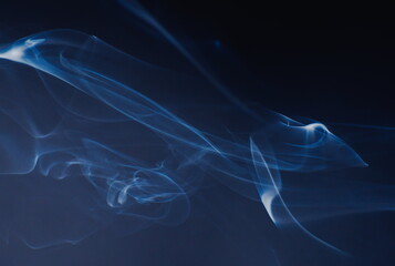 Abstract photographs of billowing smoke swirling and moving in the air.