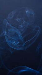 Abstract photographs of billowing smoke swirling and moving in the air.