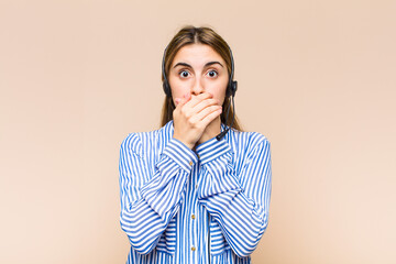 blonde pretty woman covering mouth with hands with a shocked, surprised expression, keeping a...