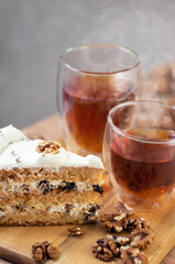 Tea in a cup with double walls and a cake with walnuts and prunes
