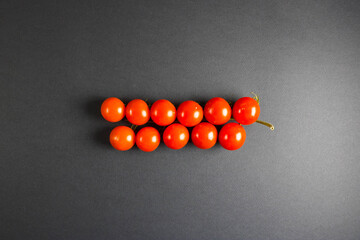 Cherry tomatoes in container isolated on black background