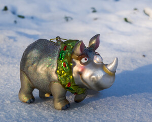 Silver Christmas toy rhinoceros in the snow closeup