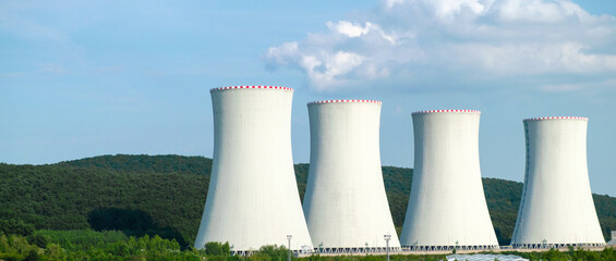 Nuclear power plant. Cooling towers on the background of blue sky and mountains