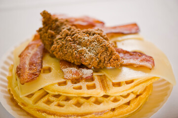 Chicken and waffles. Classic American Diner Style Breakfast or Brunch menu item favorite. Crispy homemade fried chicken on top of home buttermilk waffles topped with butter and maple syrup. 