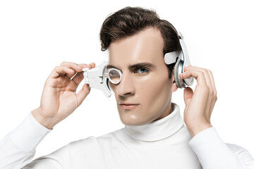 Cyborg looking at camera while touching digital eye lens and headphones isolated on white