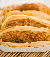 Chicken and waffles. Classic American Diner Style Breakfast or Brunch menu item favorite. Crispy homemade fried chicken on top of home buttermilk waffles topped with butter and maple syrup. 