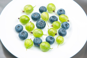 fresh different berries on a white plate. useful vitamin healthy food fruit. healthy vegetable breakfast