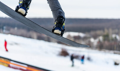 Jumping legs on snowboard on track background