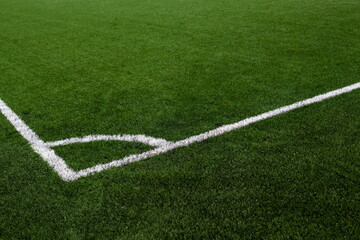 Artificial grass football field with white line corner on the green soccer field