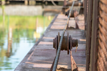 A long metal cable running along the ferry crossing. Old rusty vintage mooring bollard for boats, ships and yachts. Control system for the ferry.