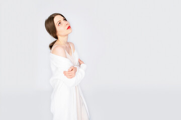 Fototapeta na wymiar Girl all in white with red lips on an isolated white background. Girl posing in fashion style clothing.