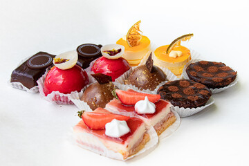 delicious tartes and cakes with fresh fruits and chocolate presented on a white background
