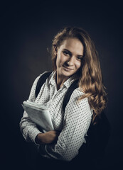 Young beautiful longhaired student girl with papers looks happy