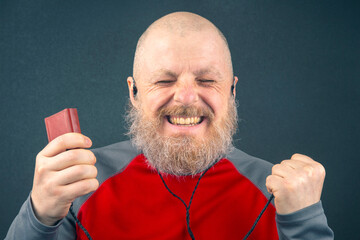 bearded man enjoys listening to his favorite music through an audio player in small headphones....