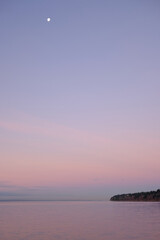 Moon rises through pastel skies over Semiahmoo Bay, White Rock