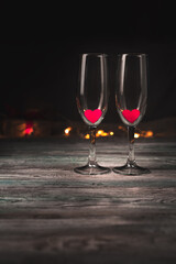 Empty wine glasses with red hearts on a brown background. Side view with space for copying. Concept of holiday backgrounds, February 14, love.
